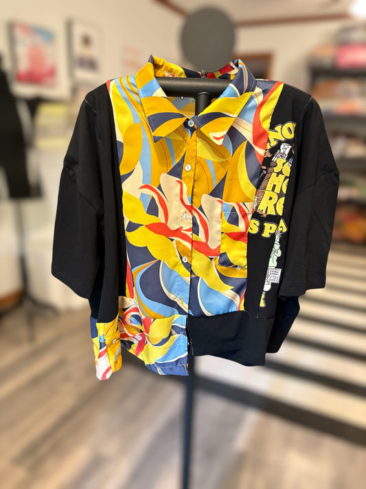 Colorful patterned short-sleeve button-up shirt with vibrant designs and contrasting black sleeves, perfect for summer style. Front