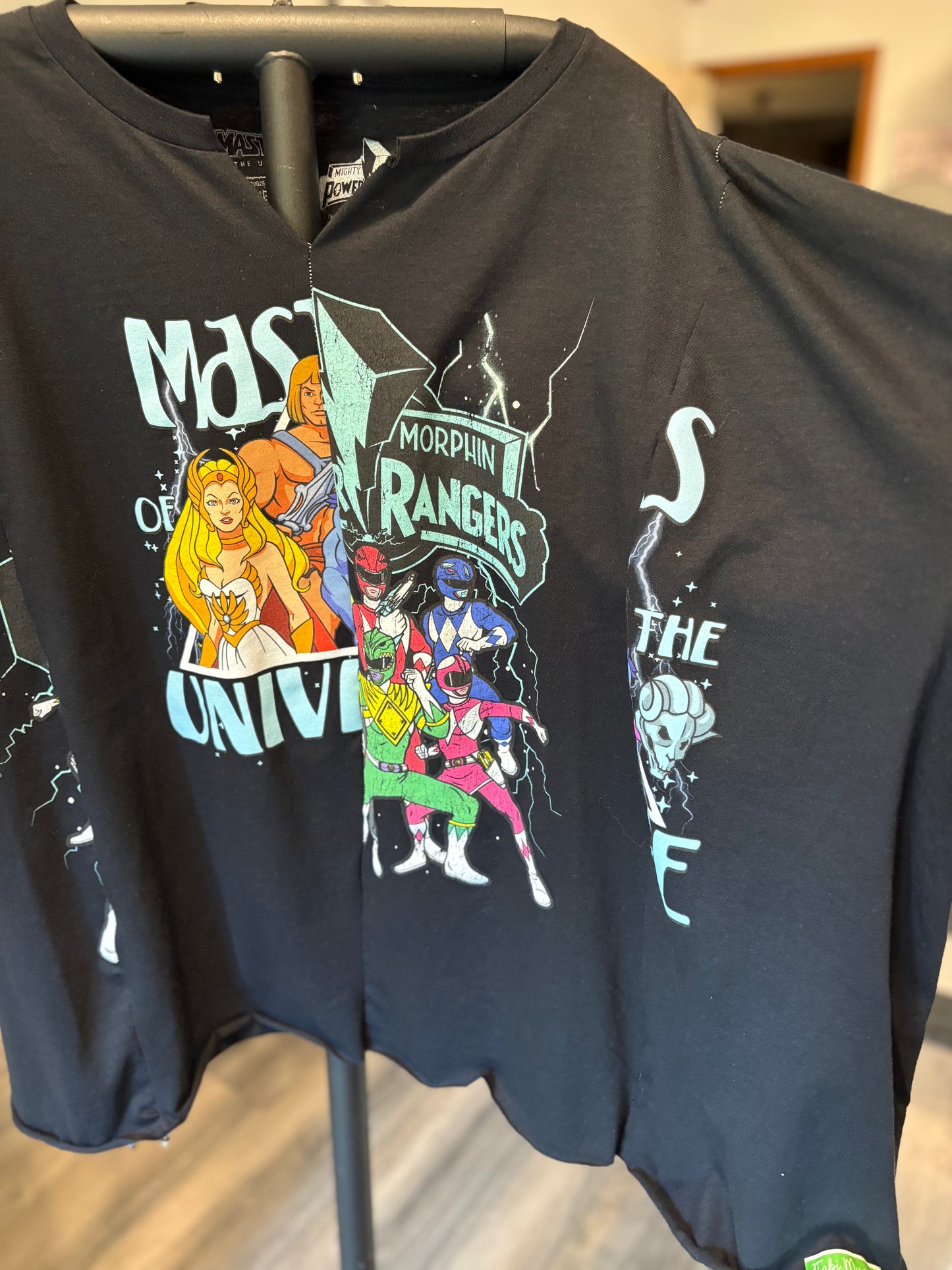 Black graphic tee featuring He-Man and Power Rangers, perfect for nostalgia lovers and pop culture fans. Detail