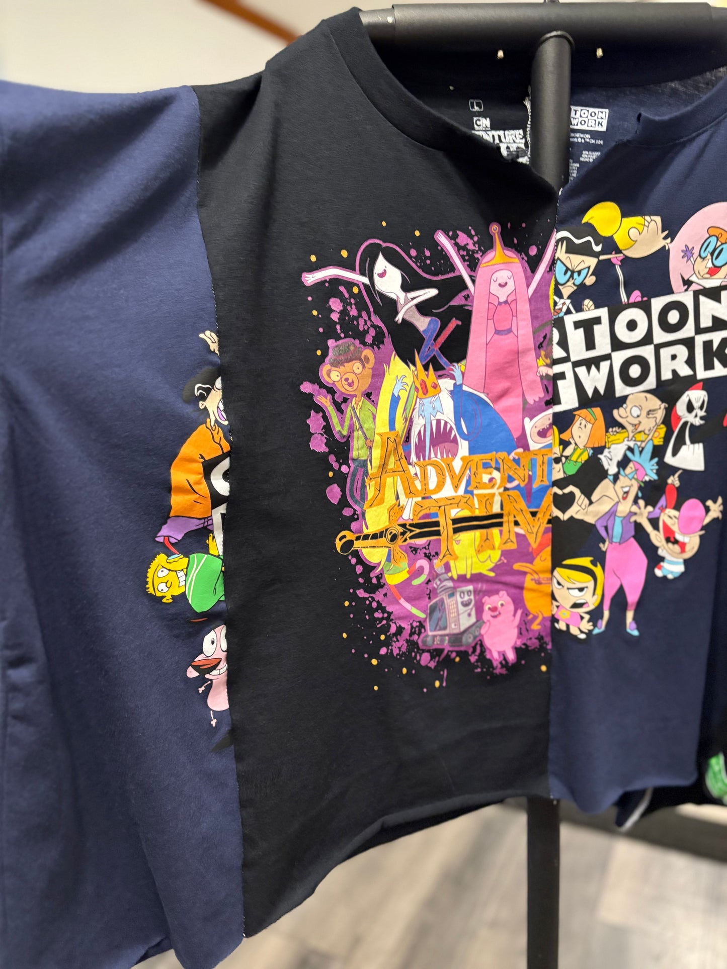 Graphic oversized tee featuring popular cartoon characters and a vibrant "Toon Work" design. Perfect for casual wear! Sleeve